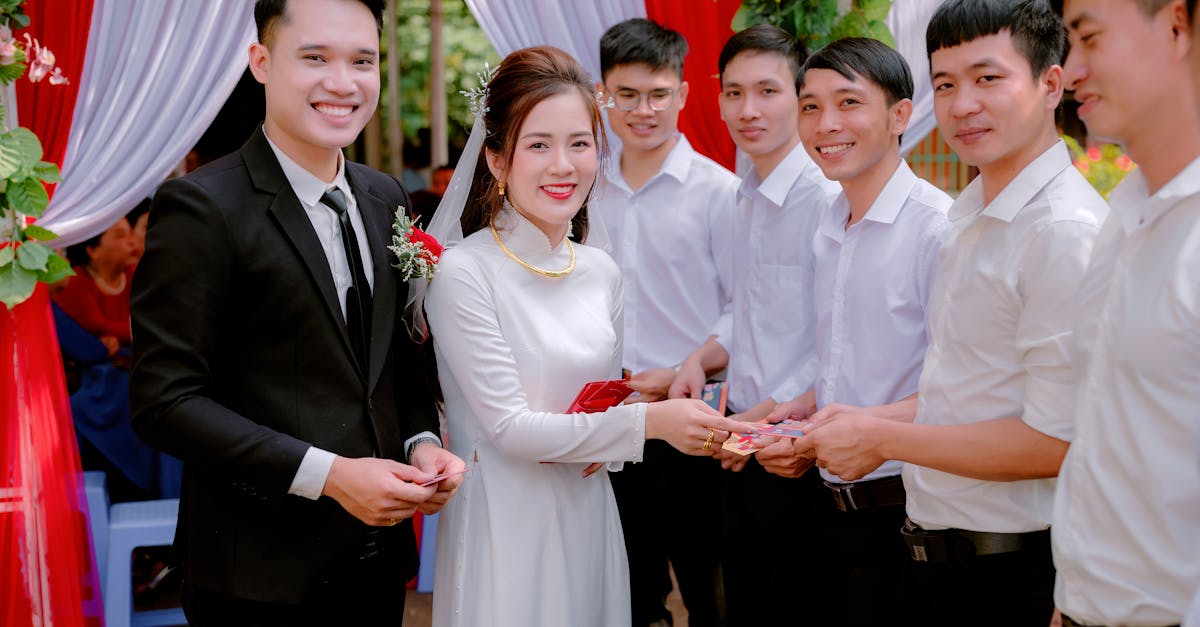 A Man in Black Suit Jacket Smiling Beside Woman in White Dress